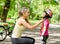 Young mother dresses her daughter\'s bicycle helmet