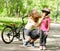 Young mother dresses her daughter\'s bicycle helmet