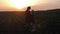 Young mother farmer teaches her daughter to work in a wheat field. Silhouette of a farmers family in a wheat field at