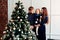 Young mother and father and their little daughter in a New Year decor with gifts and a Christmas tree