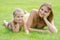 Young mother and five year old daughter lying on green grass and looking to frame