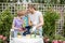 Young mother gardening in front or back yard with her two cute little children