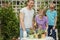 Young mother gardening in front or back yard with her two cute little children