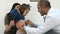 Young mother with girl being examined by male pediatrician with stethoscope