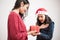 Young mother gives a red pretty present for xmas to her daughter on white background