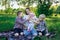 Young mother having picnic in nature with three children. Concept candid happy family