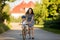 Young mother, helping her son to learn how to ride a bike, holding him and teaching him