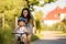 Young mother, helping her son to learn how to ride a bike, holding him and teaching him