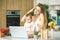 Young mother with her baby daughter in a modern kitchen setting. Young attractive cook woman desperate in stress