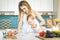 Young mother with her baby daughter in a modern kitchen setting. Young attractive cook woman desperate in stress