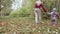 Young mother and her little daughter walk in autumn park.