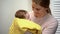 Young mother holding adorable baby in arms, artificial feeding, newborn care