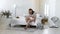 Young mother holding her newborn child. Mom nursing baby. Woman and new born boy relax in a white bedroom. Mother breast