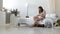 Young mother holding her newborn child. Mom nursing baby. Woman and new born boy relax in a white bedroom. Mother breast