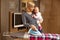 Young mother ironing with baby in arm