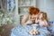 Young mother kiss her little daughter at the desk