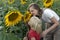 Young mother and little boy are sniffing sunflower. Trusting relationship between son and mother