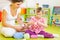 Young mother and little daughter decorating Easter eggs