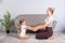 Young mother and little daughter keeping eyes closed sitting on floor, holding hands together and practicing yoga at home