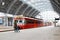 Young mother and little kid walk through the Bergen train station platforms with typical red Voss train on background, Bergen.