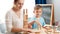 young mother with little son playing and building high tower with wooden blocks or bricks. Mother educating and teaching