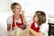 Young mother and little sweet daughter in cook apron cooking together baking at home kitchen