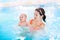 Young mother and newborn baby in swimming pool