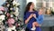 A young mother with a newborn son decorate the Christmas tree at home.