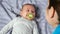 Young mother plays with baby boy making son with dummy smile