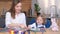 A young mother plays educational games with her daughter while sitting at the kitchen table.