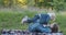 Young mother plays with her little daughter on picnic in park. Girl flies on mom feet.