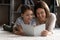 Young mother and preteen daughter relax on carpet read book