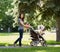 Young Mother Pushing Stroller In Park