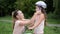 Young mother puts a bicycle helmet on the head of her daughter to her child while riding a bike in the park