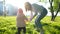 Young mother raises her baby in her arms and walks in the park.