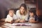 Young mother, read a book to her tho children, boys, in the living room