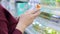 A young mother reads the composition of baby food. A young woman buys baby food in a supermarket. The girl standing at