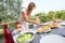 Young mother serving lunch to children on terrace