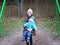 Young mother sits with her baby on a swing