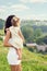 Young mother with a small daughter in his hands standing on the edge of the cliff and looks into the distance over the city