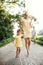 A young mother with small daughter playing hopscotch on a road in summer.