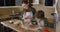 Young mother and son cooking cookies together in the kitchen. Mom and baby boy cut out homemade cookies with shapes form