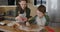 Young mother and son cooking cookies together in the kitchen. Mom and baby boy cut out homemade cookies with shapes form