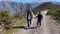 Young mother and son enjoy a scenic walk on a pebble pathway surrounded by majestic mountains, overlooking the