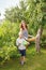 Young mother and son harvest apples