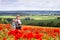 Young mother with a son and a newborn daughter in gorgeous poppy flower field