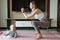 Young mother in sport clothing exercising at home with baby. Online training during coronavirus covid-19 quarantine