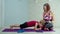 Young mother in sportswear helping preschooler boy to do plank exercise at home. Happy family doing home fitness with