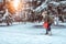 A young mother supports a young son, a boy of 3 years. In winter, outside in park, background is snow drifts of