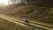 A young mother teaches his daughter to ride a Bicycle and a Bicycle helmet in nature near the hill . shooting on a drone